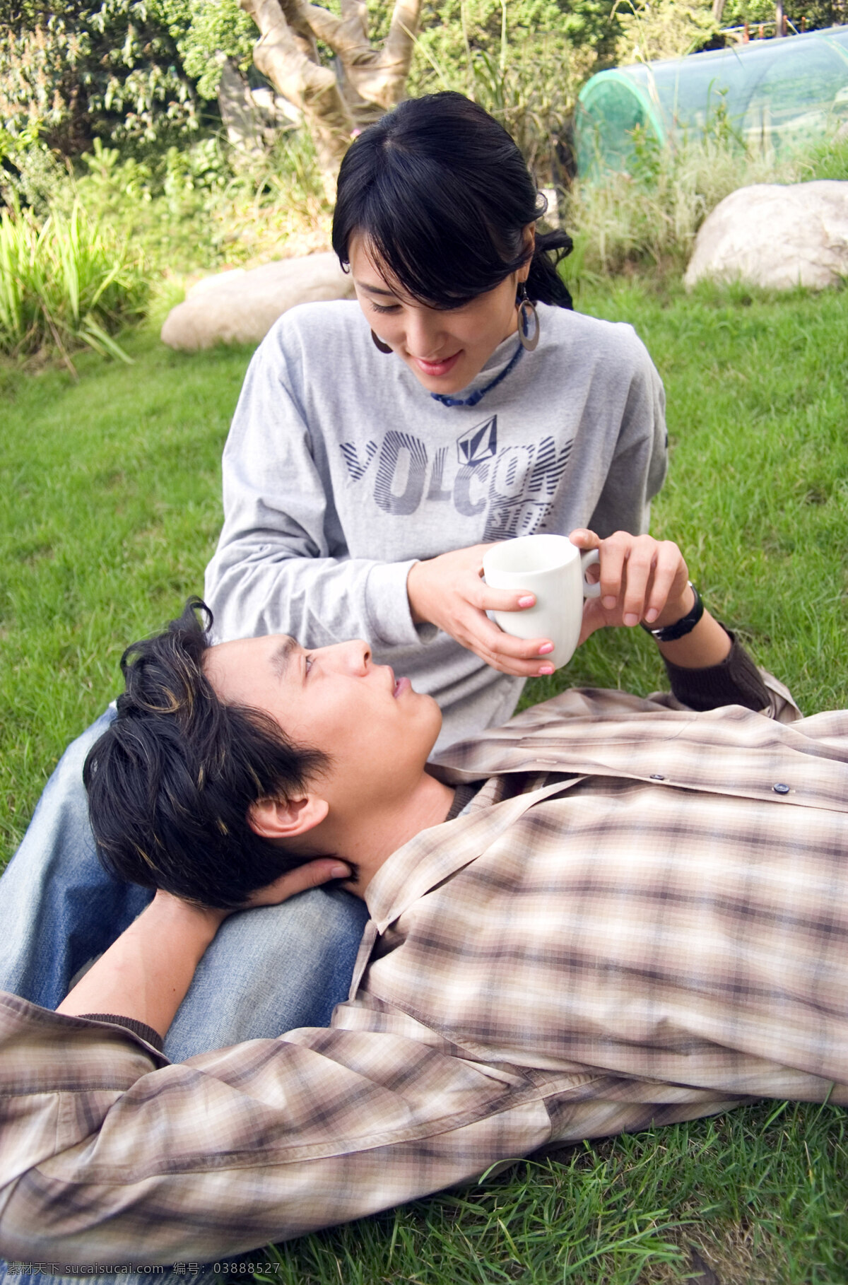 草地 上 情侣 男性 男人 女性 女人 夫妻 休闲时光 生活 享受 户外 公园 坐着 躺着 递茶杯 恩爱 石头 树木 生活人物 人物图片